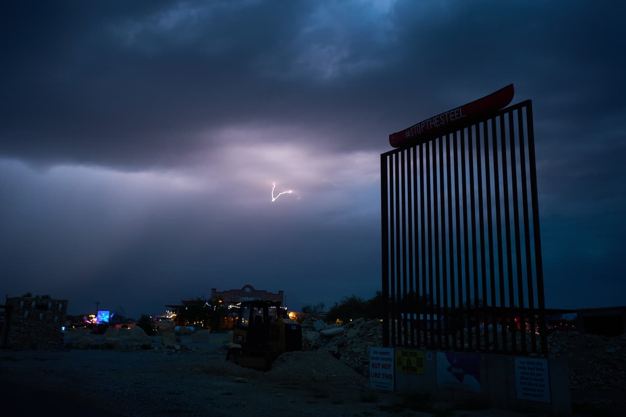 Un relámpago ilumina el cielo detrás de un tramo del muro fronterizo en protesta contra las barreras propuestas a lo largo de la frontera, el jueves 24 de septiembre de 2026, en Terlingua, Texas.