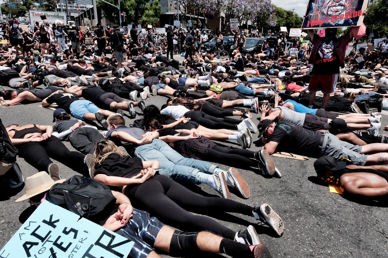 Los miembros de la comunidad LGBTQ se unen a los manifestantes de Black Lives Matter mientras bloquean una intersección tendidos en la calle con las manos a la espalda en West Hollywood, California.