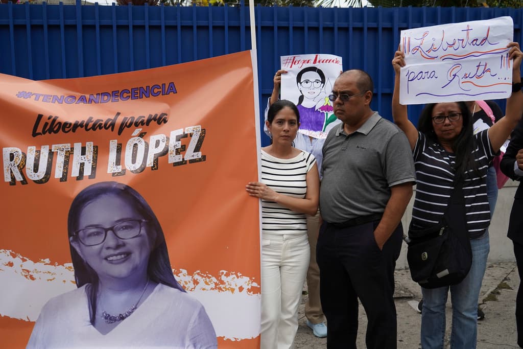 Defensores de la abogada salvadoreña Ruth López junto a un cartel con su imagen protestan tras su detención, el 4 de junio de 2025.