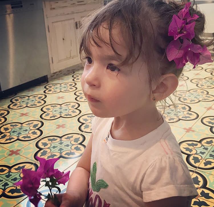 A ella le encanta recolectar flores para mamá, y de paso se queda con algunas para ella.