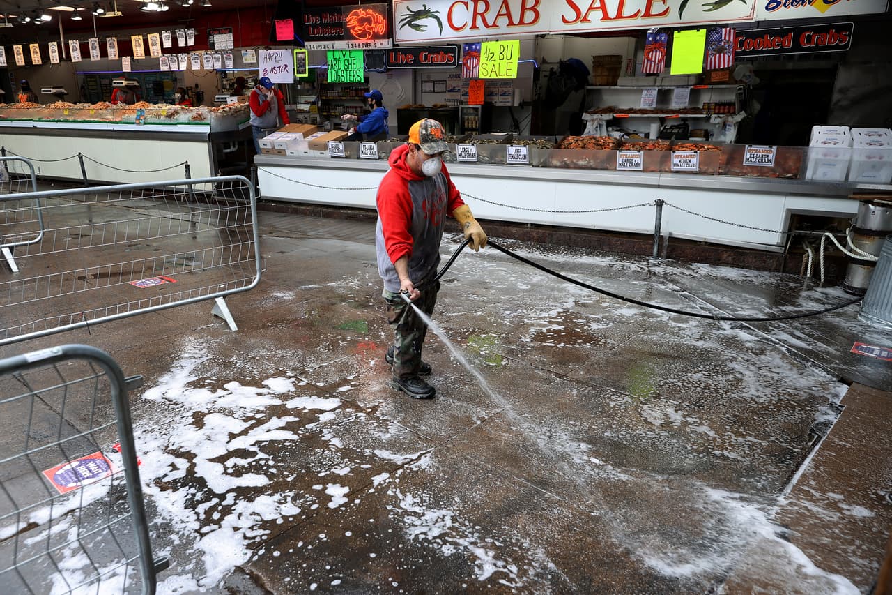 Empleados acondicionan la pescadería municipal de Washington DC, reabierta después de varias semanas. Las autoridades establecieron reglas estrictas de distanciamiento a los clientes y vendedores para poder autorizar la reapertura.