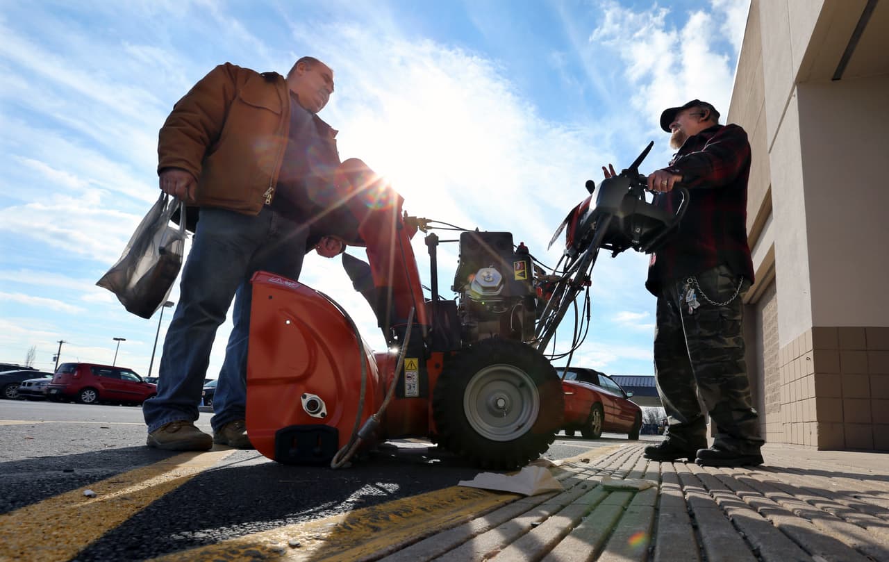 Richard Warner, de Newtown, y un hombre no identificado, discuten los pros y los contras de los diferentes quitanieves afuera de un almacén.