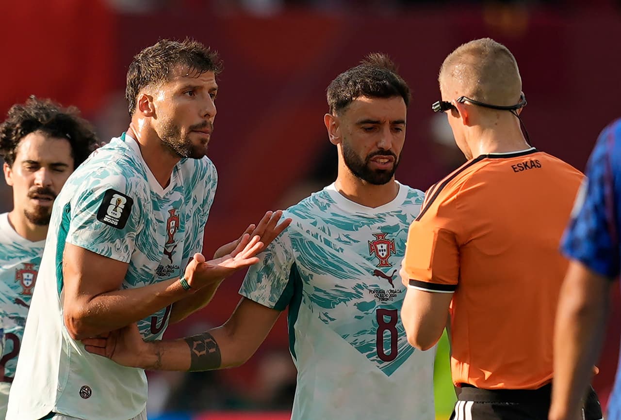El portugués Rúben Dias (3) reacciona tras recibir una tarjeta amarilla del árbitro noruego Espen Eskas, mientras su compatriota Bruno Fernandes (8) observa la escena, durante el partido de dieciseisavos de final de la Copa del Mundo entre Portugal y Croacia en Toronto, el jueves 2 de julio de 2026.