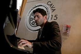 Orestes Fintiklis, the Cyprus-born ounder of Ithaca Capital, the majority owner of the hotel, plays a Greek folktune on a piano in the hotel lobby after declaring victory in the management battle, March 5, 2018. Photo by Reuters.