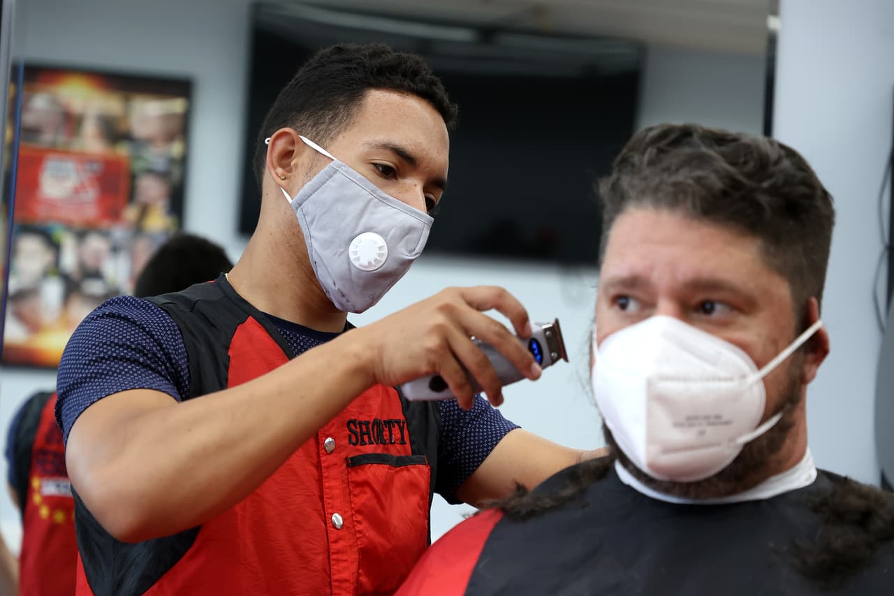 Wandy De La Cruz le corta el pelo a Luca Caravello en la peluquería 7 Stars Barber en Bellmore, Nueva York. Las peluquerías y barberías fueron autorizadas a abrir esta semana cuando la región entró en la fase II de reapertura.