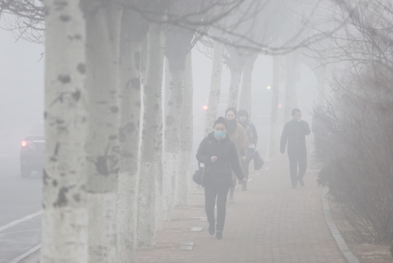 Una acera por donde transita un grupo de peatones está totalmente cubierta de humo en Dalian, ciudad al norte de China. Otra de las más afectadas es Tianjin, a unas 85 millas (140 km) de la capital, donde en la mañana del lunes se vieron obligados a cancelar cerca de 180 vuelos y otros 60 fueron retrasados, según informó AFP.