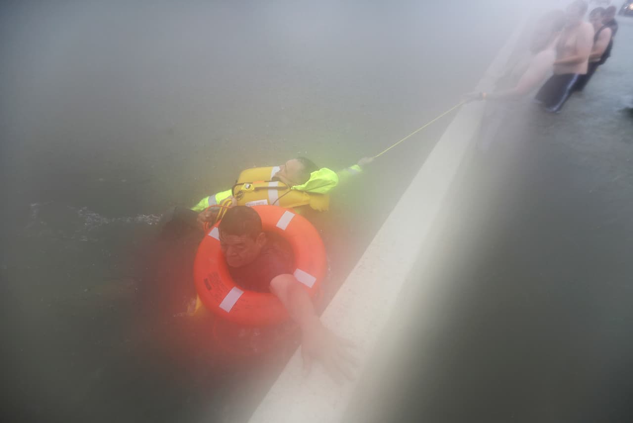 Wilford Martínez es rescatado de su carro inundado en la Interestatal 610. El alcalde de Houston asegura que toda la ciudad está bajo el agua.