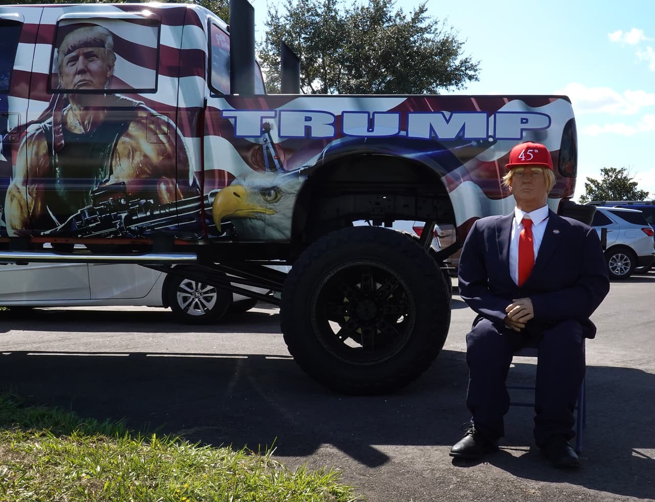 Un maniquí y una imagen que exalta a Trump como un militar que dispara un arma, las escenas antes del inicio de un mitin de campaña para el presidente Donald Trump en el Aeropuerto Internacional Orlando Sanford el 12 de octubre de 2020 en Sanford, Florida.