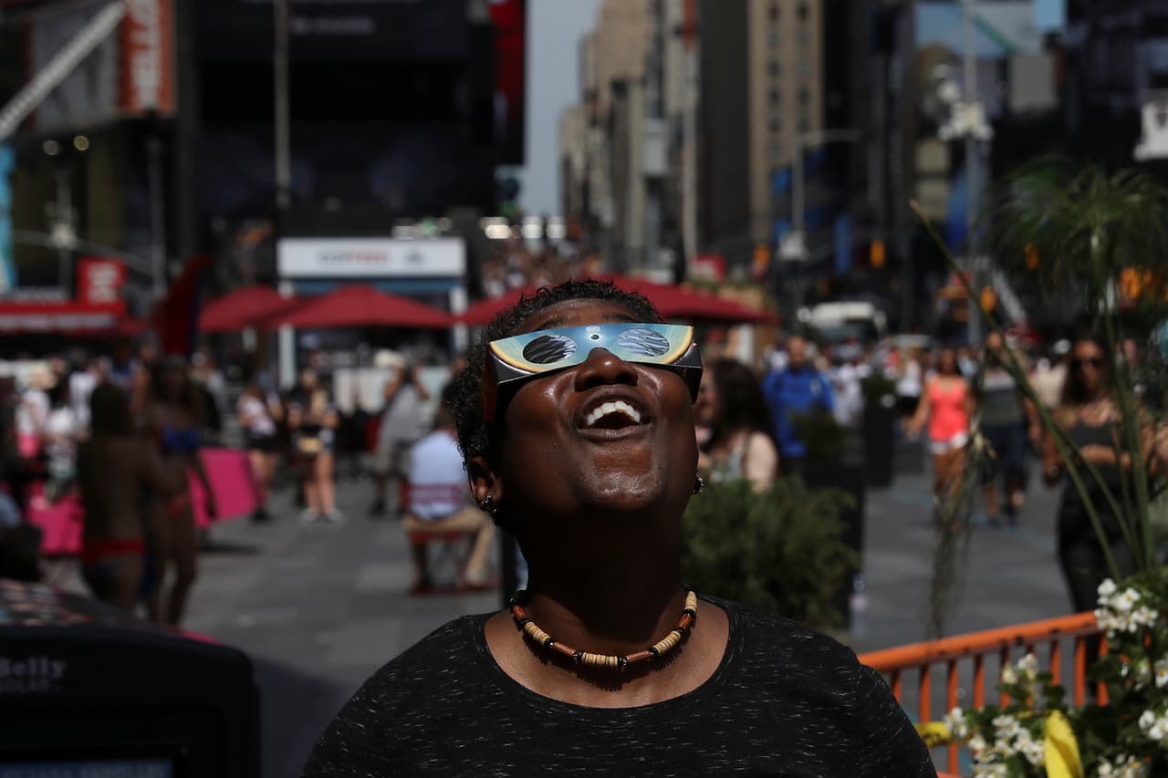Otra neoyorquina fascinada con el espectáculo solar. (Shannon Stapleton/Reuters)