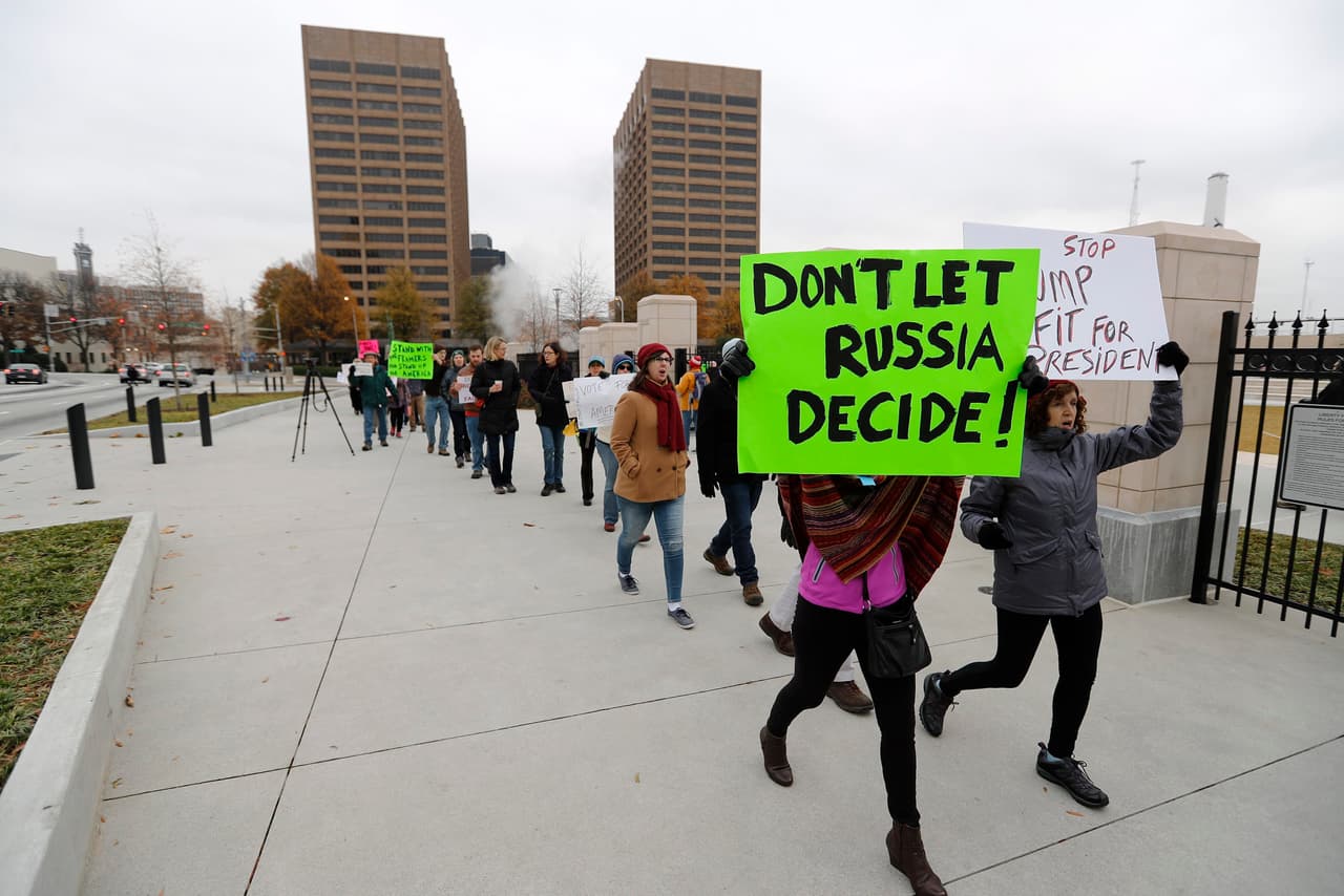 Ciudadanos estadounidenses se manifiestan afuera del Capitolio Estatal de Georgia, antes del encuentro de los dieciséis electores del estado, que emitirán sus votos este 19 de diciembre de 2016. El Colegio Electoral de EE.UU se reúne este lunes para certificar la victoria del republicano Donald Trump.