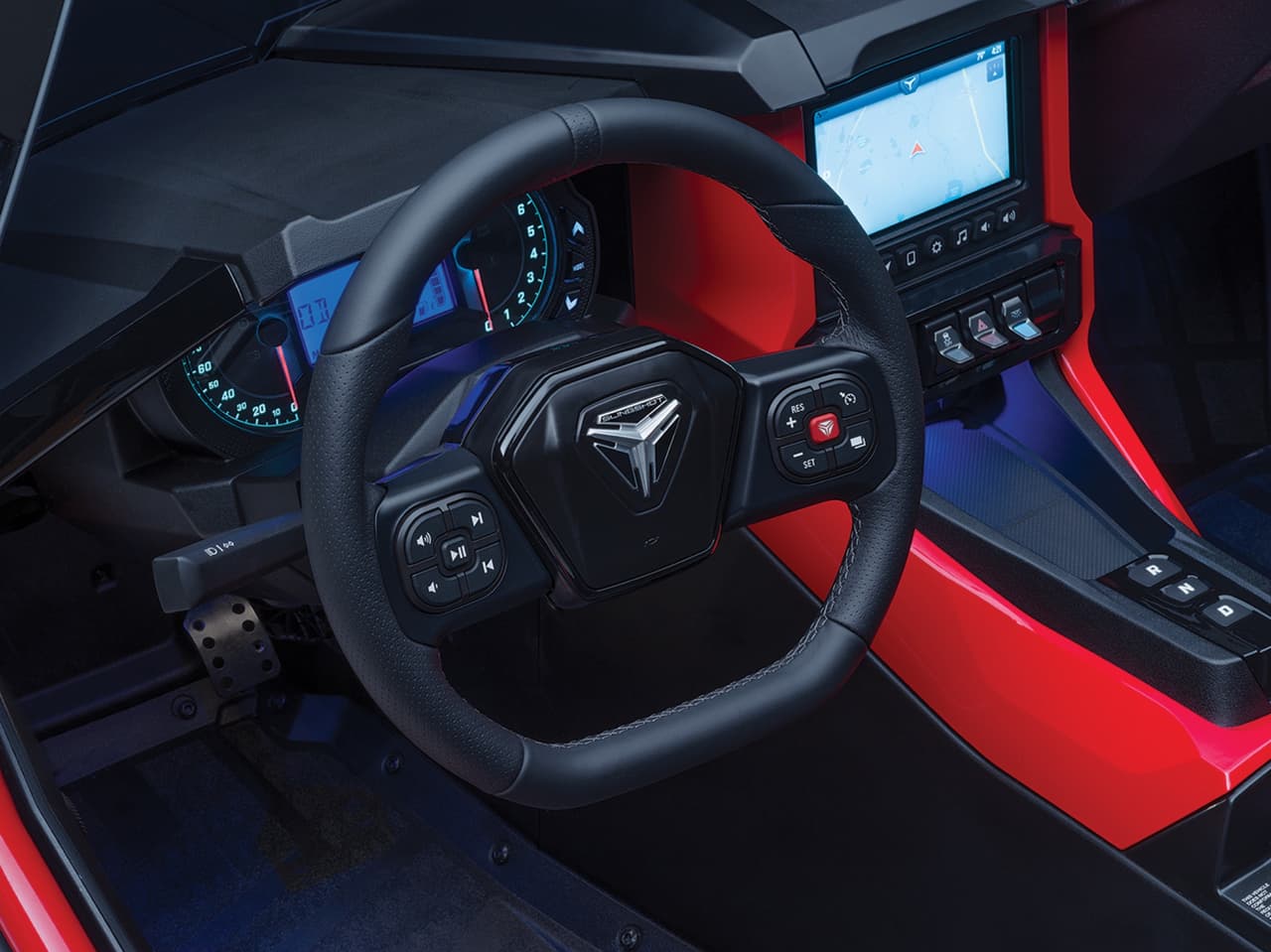 Su volante del tipo ‘D’ (parte baja plana) fue también rediseñado cubierto en cuero con costuras. Sobre este están los botones que controlan los modos de manejo “Comfort” (el más civilizado) y “Slingshot” (el más extremo).