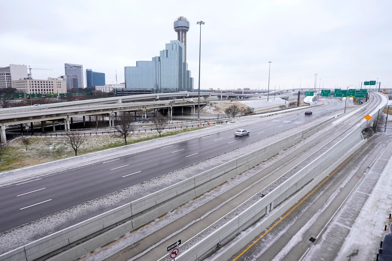 Una parte del horizonte de la ciudad de Dallas se ve a lo largo de la IH 30 y la IH 35, mientras que los conductores navegan por las condiciones de la carretera fangosa y helada, miércoles, 1 de febrero de 2023.