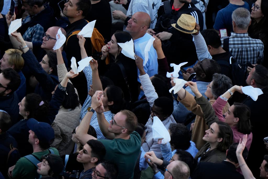 La gente reacciona ante columnas de humo blanco que salen de la chimenea de la Capilla Sixtina, donde 133 cardenales se reúnen en el segundo día del cónclave para elegir al sucesor del difunto Papa Francisco, en el Vaticano, el jueves 8 de mayo de 2025. (Foto AP/Luca Bruno)