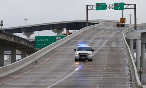 Una patrulla de policía bloquea el acceso de vehículos a la rampa que da acceso al periférico 8, cerca de la carretera 290. Los puentes y vías elevadas presentan acumulación de hielo.