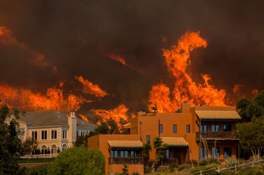 Las llamas del incendio forestal bautizado como Woolsey devora casas en Malibu, California.