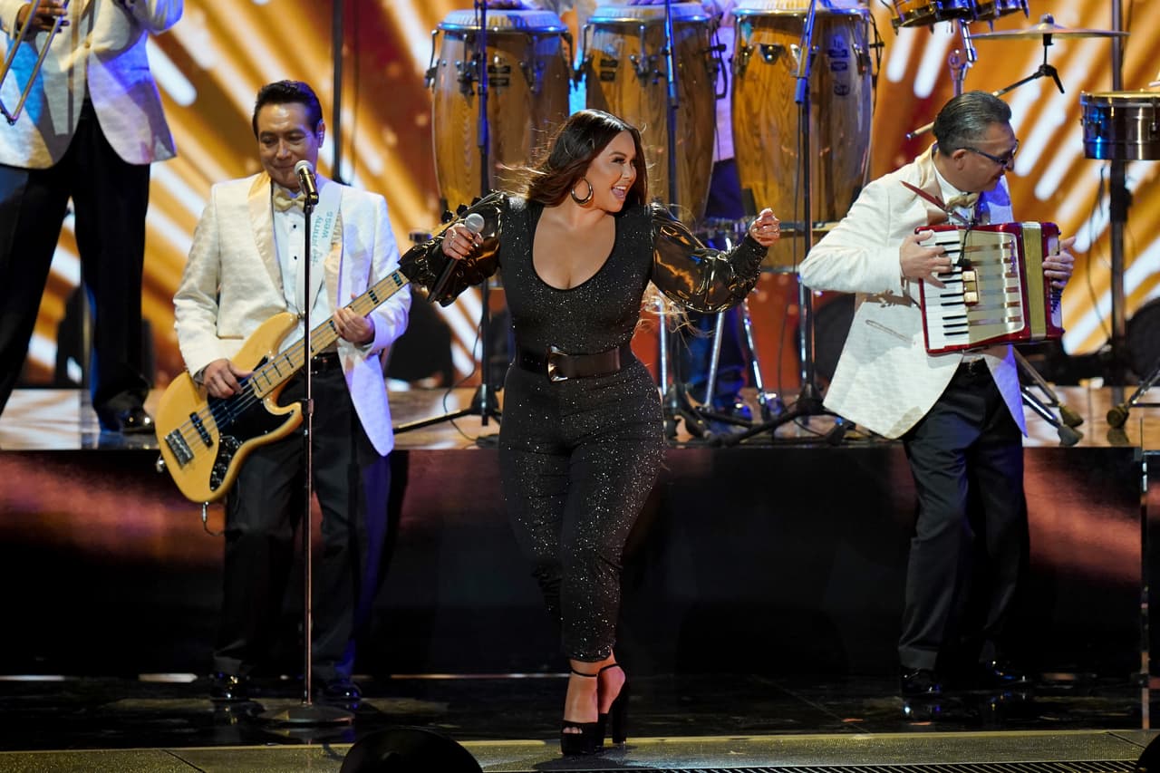 La primera en cantar junto al grupo musical mexicano fue Chiquis Rivera, quien prestó su voz para el tema 'Listón de tu pelo'.