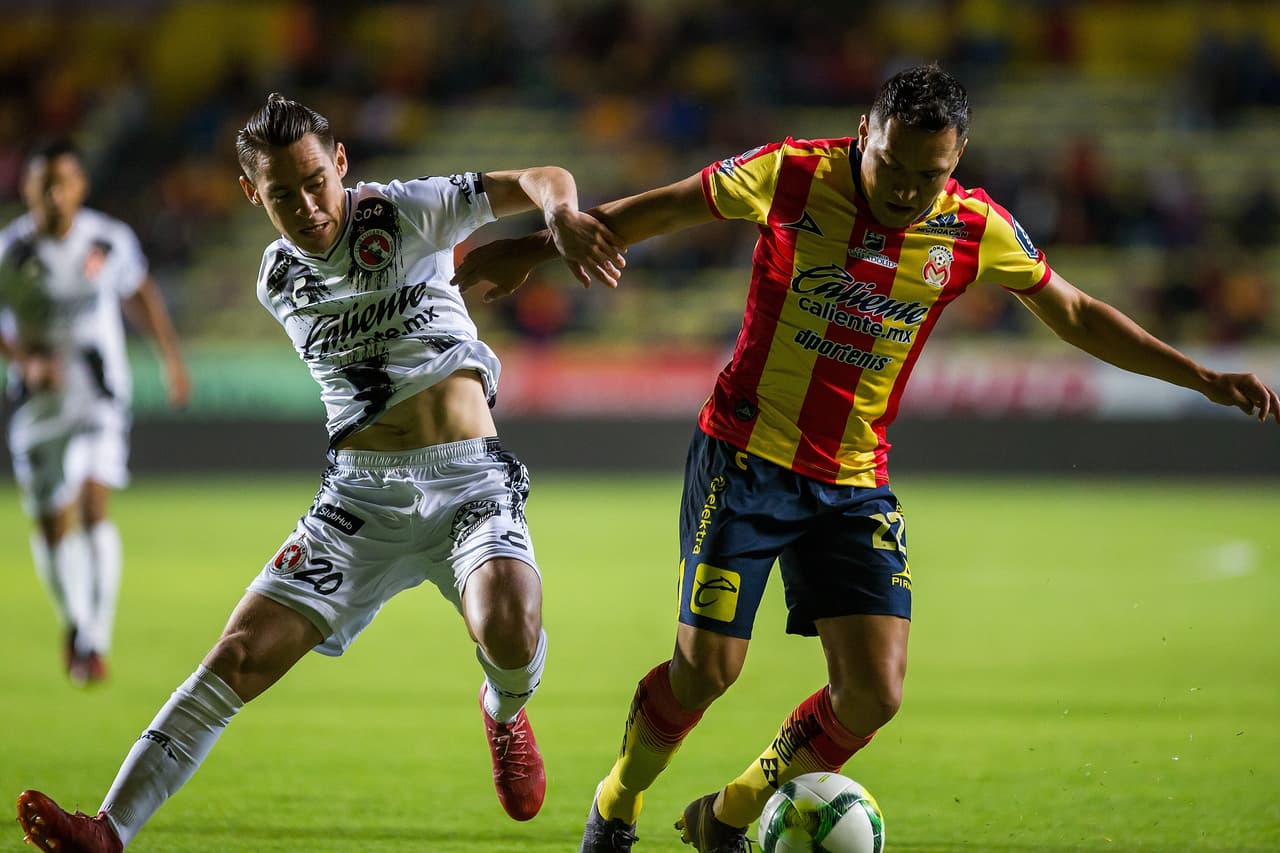 Alberto Acosta (22) y Jesús Angulo peleando codo con codo el balón en zona defensiva de Monarcas, pues los Xolos querían decir presente en el partido.