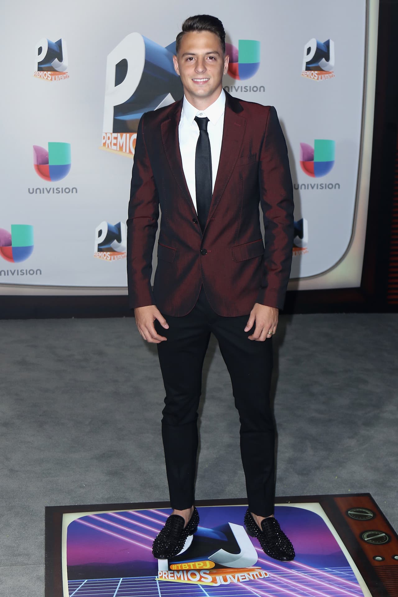 El futbolista colombiano Santiago Arias dio buena nota con su traje color tinto.