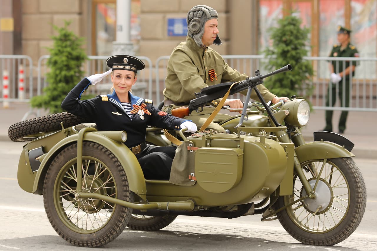 En la parada militar desfilaron también vehículos que se utilizaron durante la Segunda Guerra Mundial, como esta motocicleta conducida por un funcionario con el uniforme soviético y una mujer que también usa el traje de época.