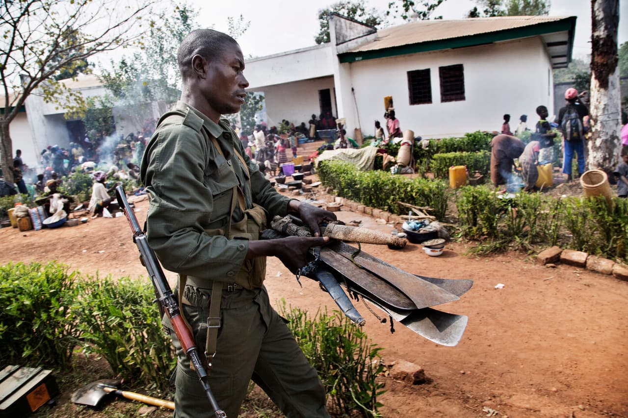 Machetes are confiscated by FOMAC peacekeepers as residents displaced by the fighting between anti-balaka and Seleka forces enter the FOMAC compound for safety.
