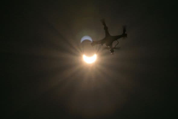 Un dron vuela en primer plano frente al eclipse visto desde Viena.