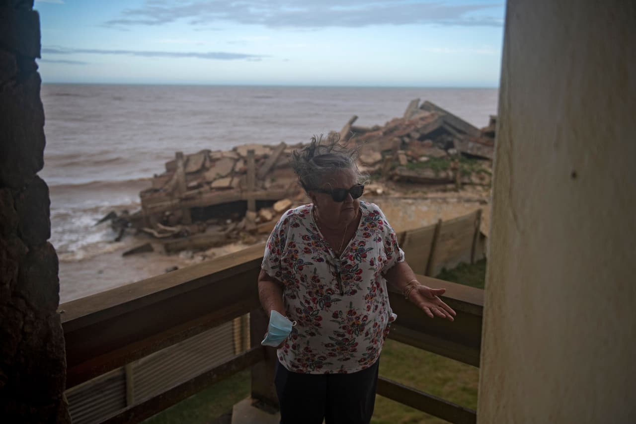 Sonia Terra Ferreira muestra los escombros de un edificio desde su balcón. Ella todavía está entre quienes guardan esperanzas. 
<b>Esta jubilada de 77 es dueña de una imponente casa de dos pisos, que debió abandonar cuando el agua empezó a carcomer su muro trasero, en 2019. </b>
<br>
<br>Viuda, se mudó a un apartamento minúsculo que construyó en su propio terreno, a la espera de una solución. Cuando llegue, "pintaré la casa de nuevo y volveré a vivir aquí", dice.