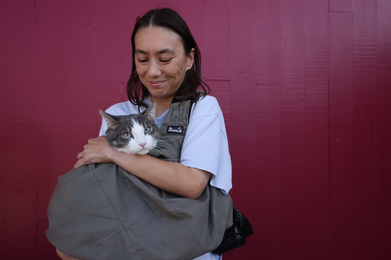 Brittany Jamison, de Westminster, sostiene a su gata "Truffles" afuera de la escuela secundaria Ocean View, un centro de evacuación el sábado 23 de mayo de 2026 en Huntington Beach, California. (Foto AP/Jill Connelly)