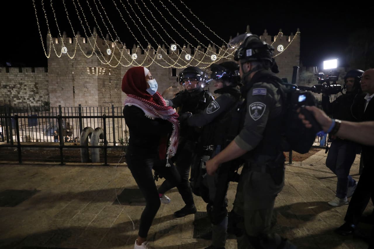 La policía encara a una mujer palestina afuera de la puerta de Damasco, que conduce a la Ciudad Vieja de Jerusalén.