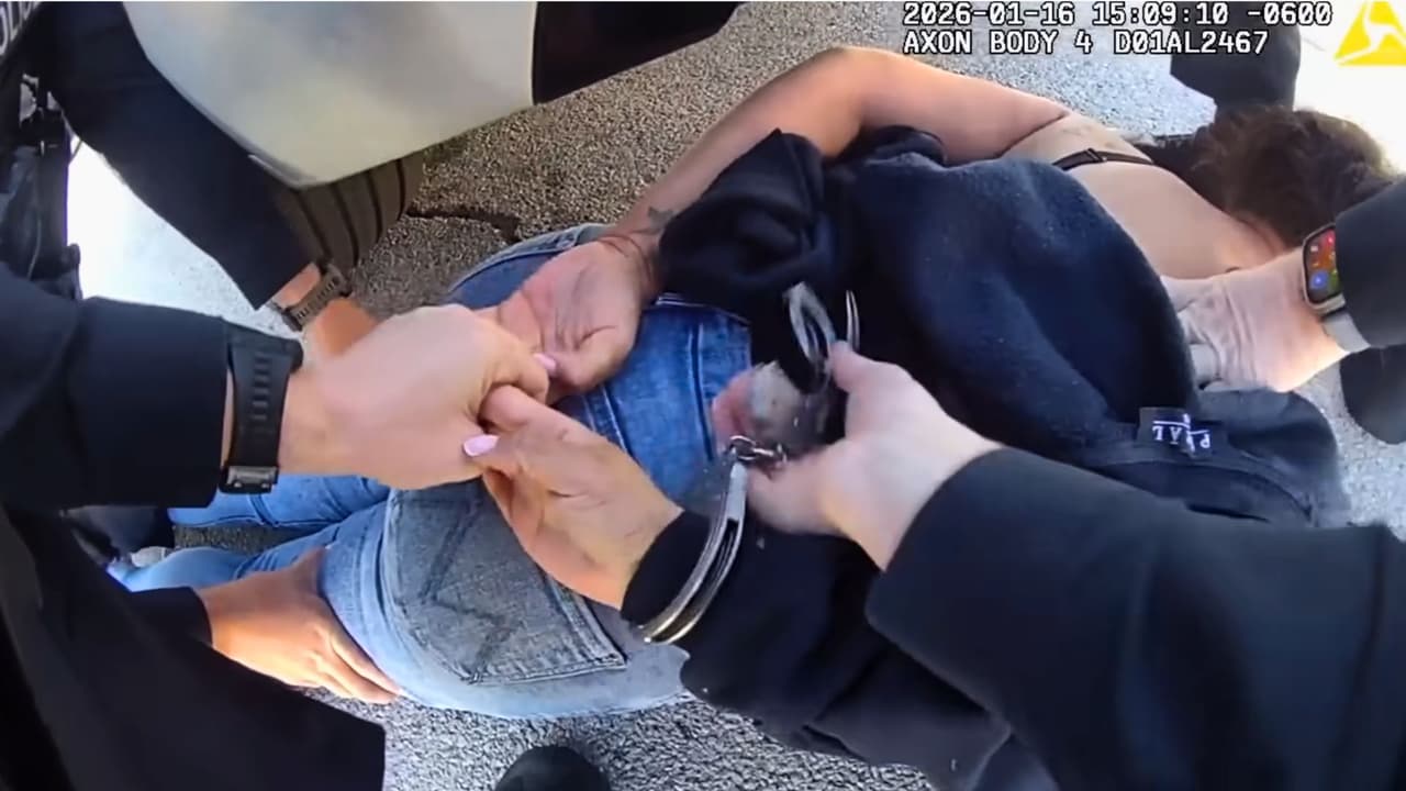 Oficiales colocan a Taneisha Thompson en el suelo para esposarla.