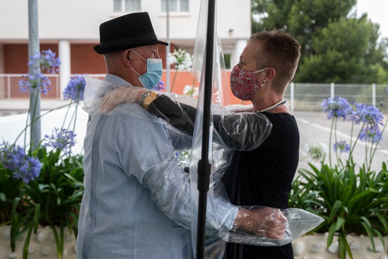 La iniciativa consiste en la interacci´ón por medio de un panel de plástico que se higinieza en cada uso, además de proveer de mangas "de usar y tirar" que permiten que, al inicio o al final de la visita, se puedan producir los abrazos entre los mayores y sus familias.
<br>
<br>Una mujer y su padre lloran a punto de abrazarse a través de la cortina protectora tras haberse reiniciado las visitas al asilo.