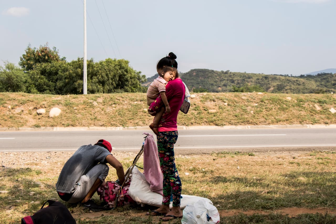 La falta de políticas públicas en las comunidades de acogida en materia migratoria pone a los niños en un mayor riesgo de sufrir discriminación, violencia, separación familiar, xenofobia, explotación y abuso, algo por lo que UNICEF ha mostrado su especial preocupación. En la imagen una venezolana y su hijo descansan de su caminata por una carretera del noreste de Colombia.