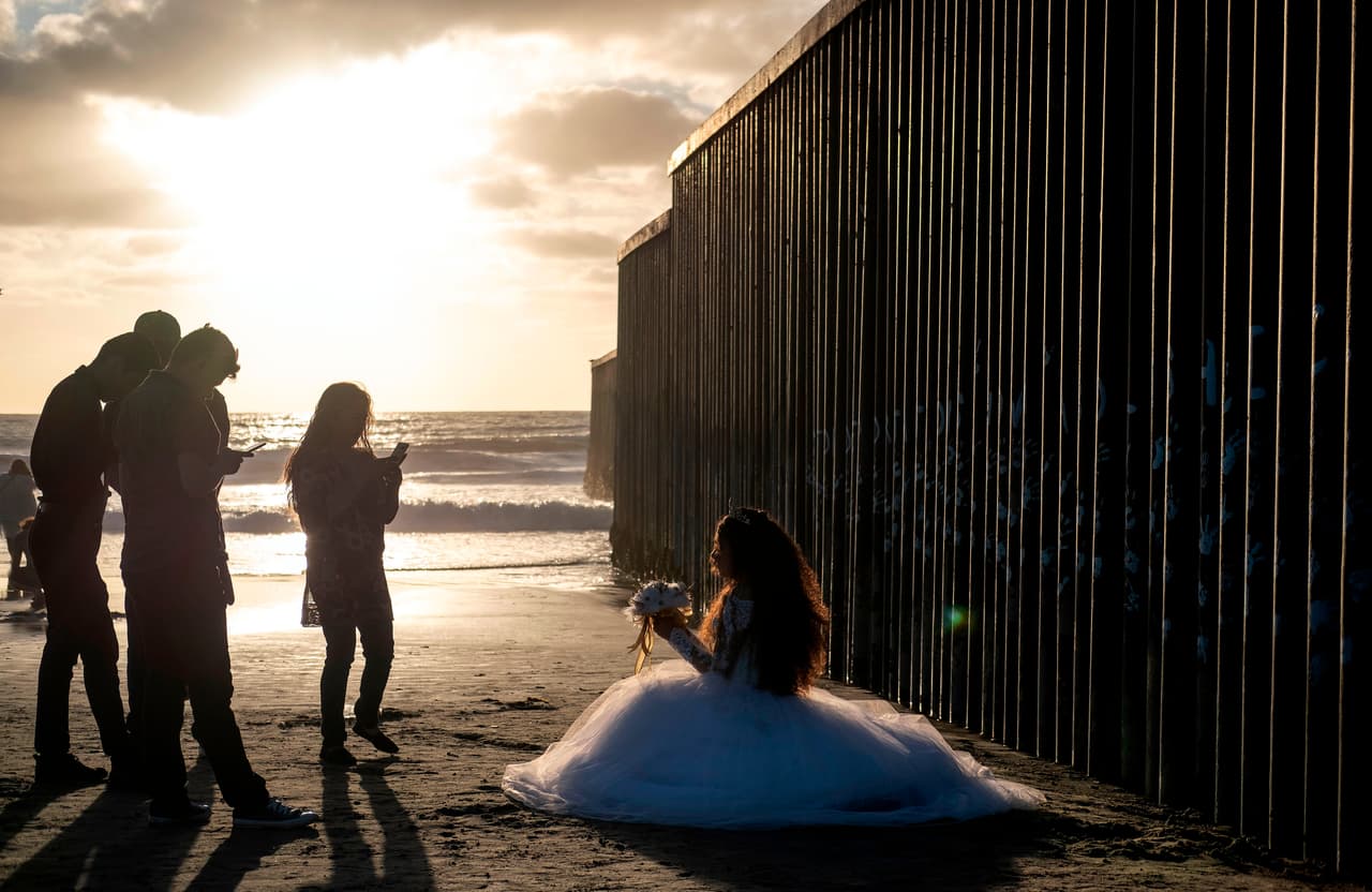 <b>Una quinceañera junto al muro.</b> La playa de Tijuana fue el lugar que escogió una joven para hacer sus fotografías por la celebración de sus 15 años, una importante tradición mexicana. El paisaje único que da la valla limítrofe entre EEUU y México al entrar al océano Pacífico 
<a href="https://www.univision.com/noticias/inmigracion/la-parte-de-mexico-donde-el-muro-fronterizo-se-volvio-una-obra-de-arte-interactiva-para-contar-historias-de-deportados">se ha convertido en un ícono de la ciudad</a>.
