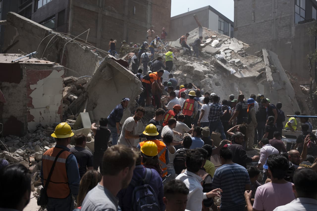 Voluntarios ayudan a remover escombros de un edificio que colapsó en Ciudad de México. El Servicio Sismológico Nacional informó que el sismo ocurrió a las 01:14 pm, tiempo del Centro de México.