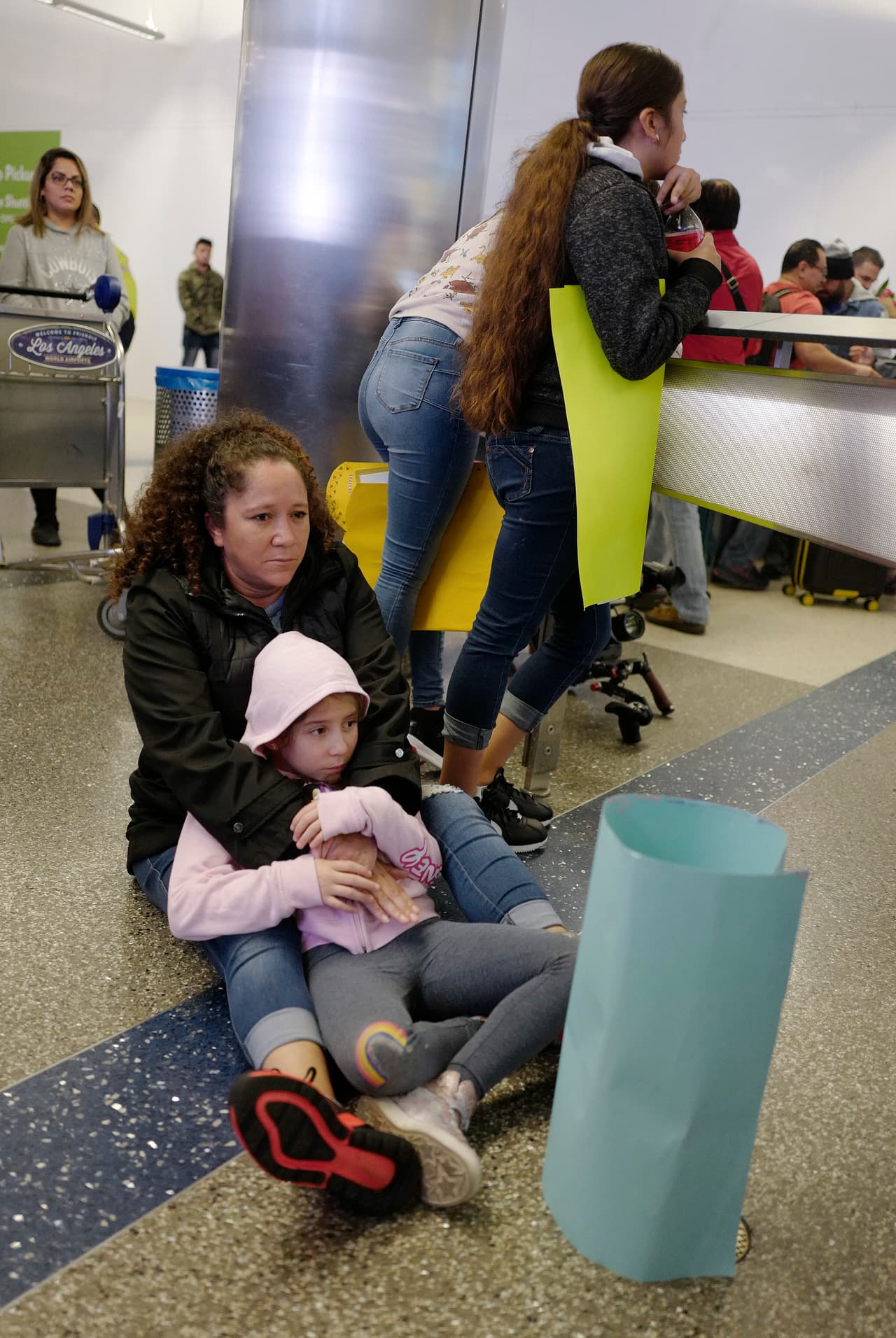 Keyli, Andrea y Alison Arredondo, junto a su madre Cleivi, esperan a su padre Fernando, que llega desde Guatemala al Aeropuerto Internacional de Los Ángeles. Los separaron en la frontera, cuando ingresaron a Estados Unidos de manera irregular en 2018. A él no lo aceptaron y regresó a Guatemala. Ahora le han dado una segunda oportunidad para presentar su solicitud de asilo, mientras se reúne con su esposa e hijas.