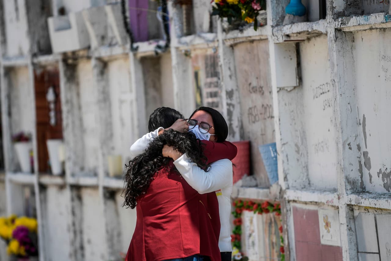 Un par de mujeres lloran junto a la tumba de un familiar antes del Día de Muertos en el panteón municipal de Nezahualcóyotl, México, en medio de la pandemia del coronavirus.