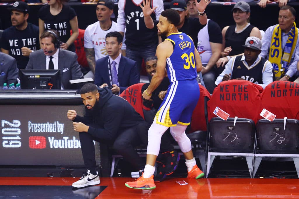 Un incómodo Stephen Curry en los minutos iniciales del primer periodo, en una jugada en la línea casi choca con el rapero Drake.