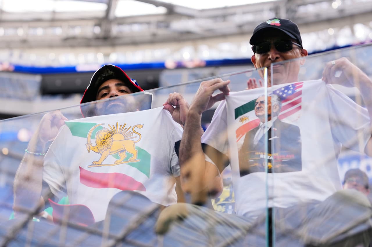 Unos asistentes muestran sus camisetas antes del partido de fútbol del Grupo G de la Copa del Mundo entre Irán y Nueva Zelanda.