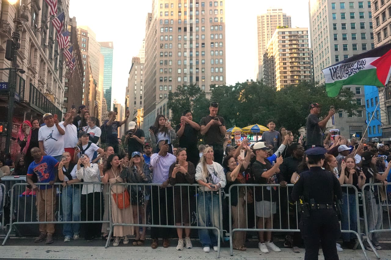 La gente observa el paso de la caravana mientras el presidente Donald Trump se dirige a un partido de las finales de la NBA entre los New York Knicks y los San Antonio Spurs en el Madison Square Garden.