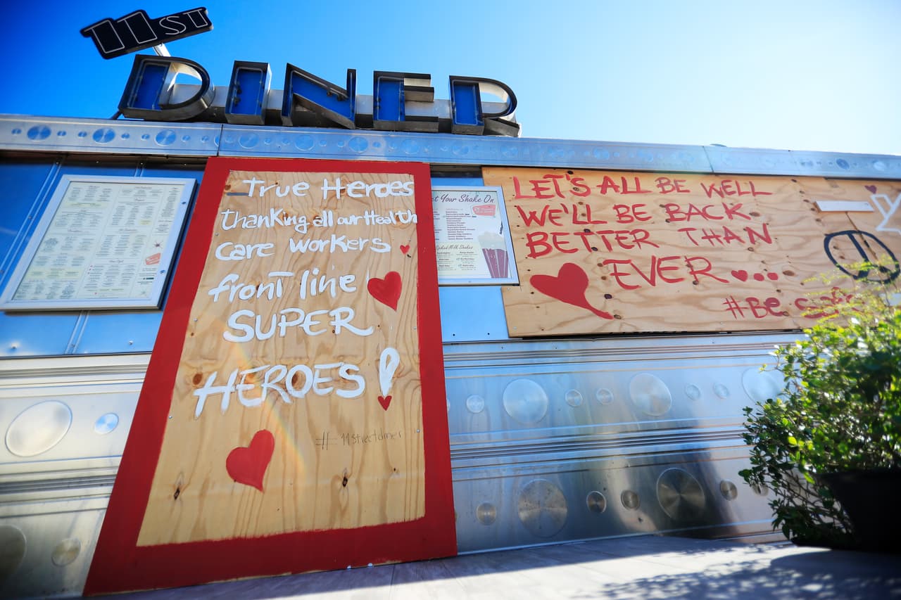 Con mensajes de ánimo pintados en los protectores de sus ventanas mientras permace cerrado, el restaurante "11th Street Dinner" en Miami Beach rinde un homenaje a los trabajadores de la salud que luchan día a día contra el coronavirus.
<br>