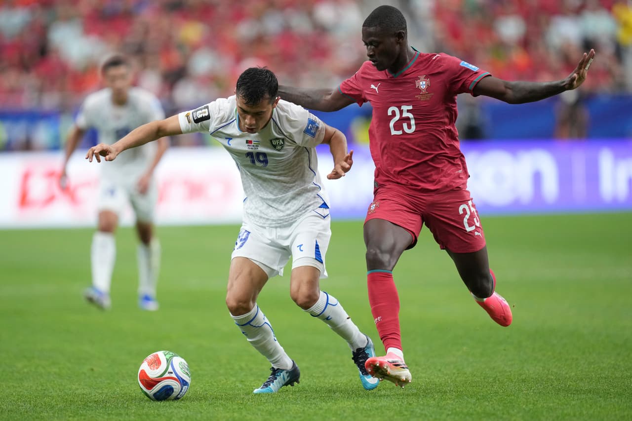 Azizjon Ganiev (19) de Uzbekistán disputa el balón con Nuno Mendes (25) de Portugal