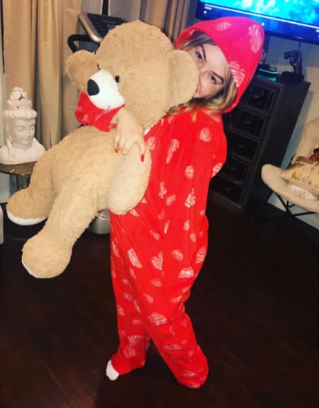 O en divertidos momentos como al presumirnos su 'onesie' o mameluco con su osito de peluche favorito.