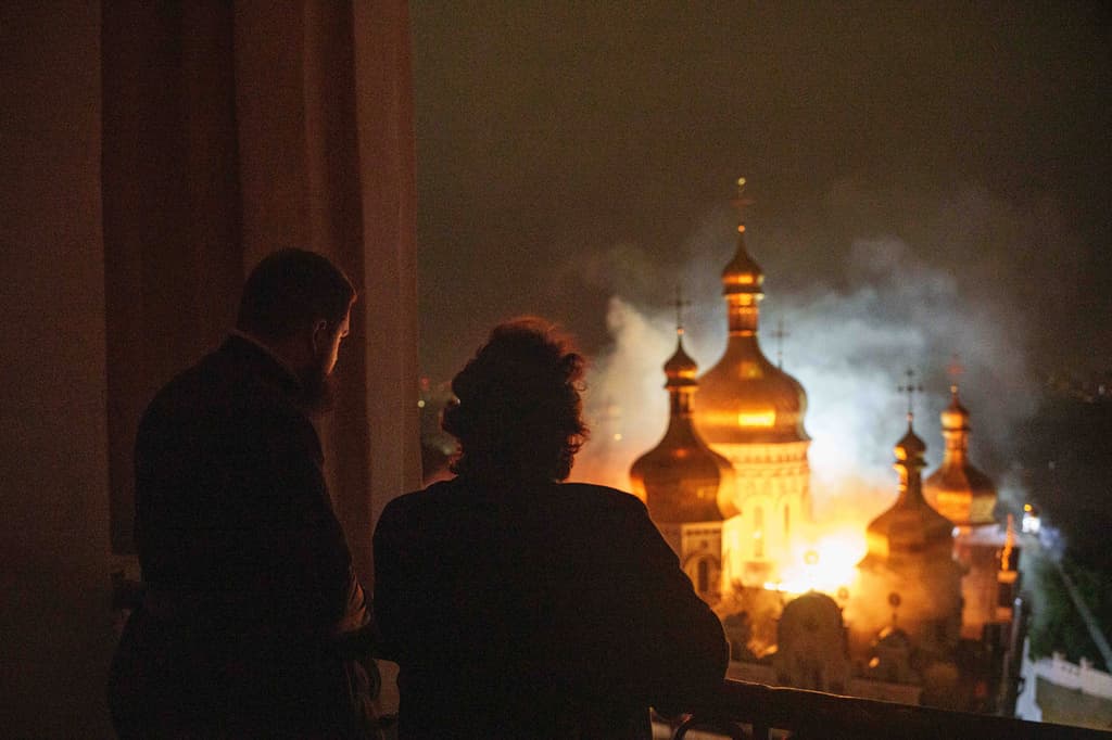 El obispo Avraamiy, a la derecha, de la Lavra de Kiev-Pechersk de la Iglesia Ortodoxa de Ucrania, observa la catedral de la Dormición de la Lavra de Kiev-Pechersk, también conocida como el Monasterio de las Cuevas, en llamas durante un ataque ruso contra Kiev, Ucrania, el lunes 15 de junio de 2026.