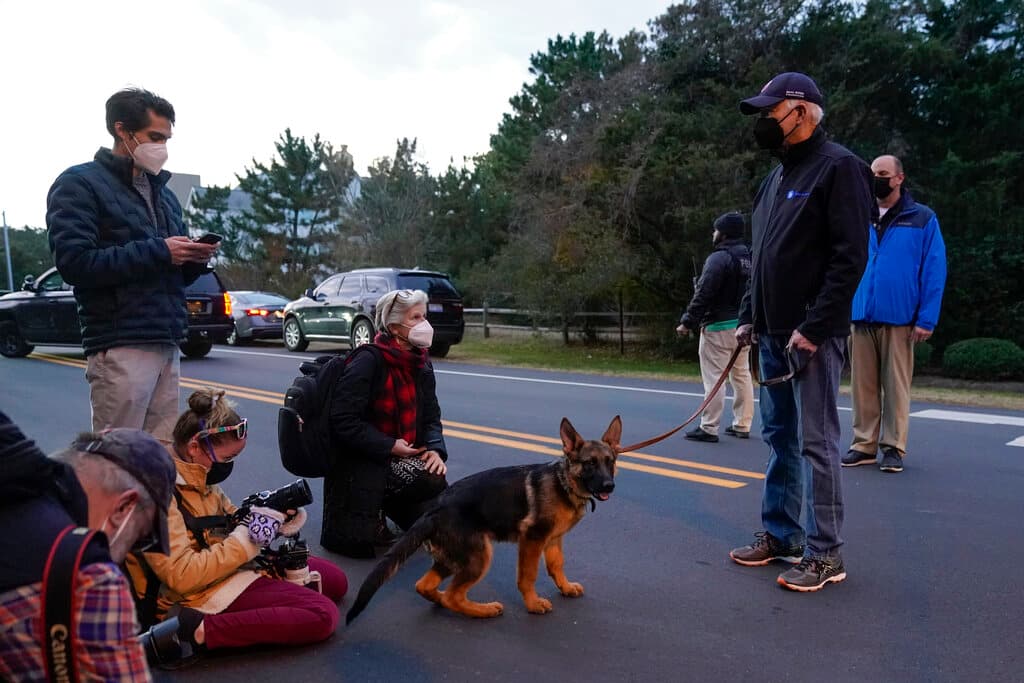 El presidente Joe Biden habla con miembros del cuerpo de prensa de la Casa Blanca mientras él y la primera dama Jill Biden llevan a su perro Commander a dar un paseo en Rehoboth Beach, Delaware.