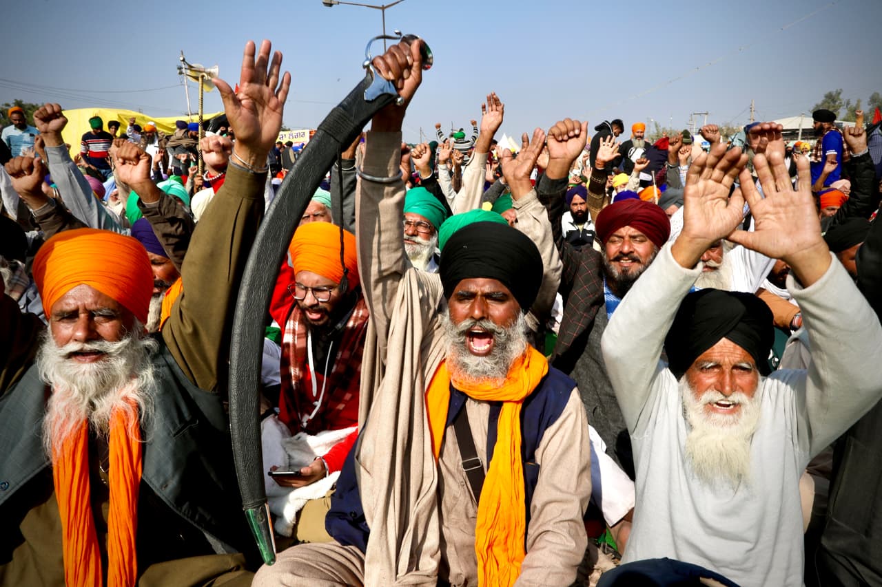FILE - In this Dec. 14, 2020, file photo, protesting farmer leaders shout slogans as they sit on a day long hunger strike at the Delhi- Haryana border, outskirts of New Delhi. India’s death toll from COVID-19 has surpassed 200,000 as a virus surge sweeps the country, rooted in so-called super-spreader events that were allowed to happen in the months following the autumn when the country had seemingly brought the pandemic under control. (AP Photo/Manish Swarup, File)