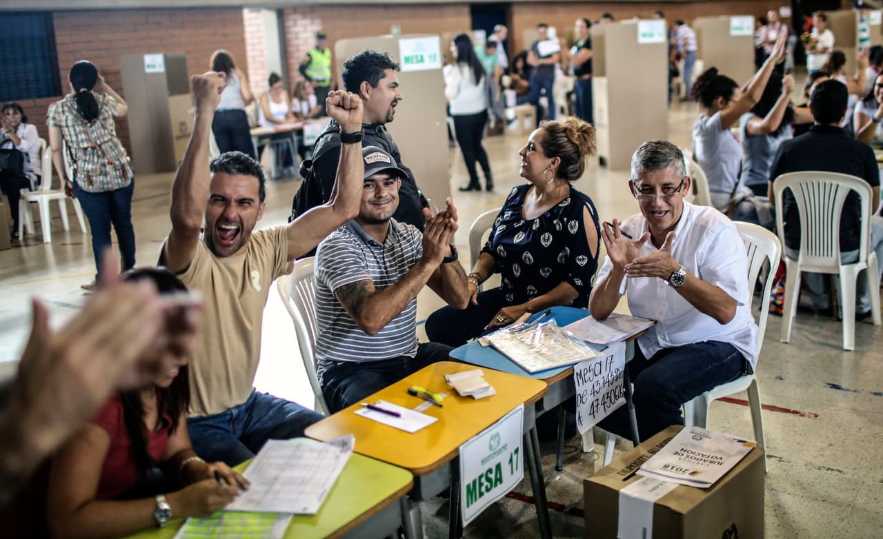Electoral officials cheer after closing the polls, during the first round of the presidential election on May 27, 2018, in Medellin, Antioquia department, Colombia. - Voters went to the polls Sunday to choose a new president of Colombia in a divisive election that is likely to weigh heavily on the future of the government's fragile peace deal with the former rebel movement FARC. (Photo by JOAQUIN SARMIENTO / AFP) (Photo credit should read JOAQUIN SARMIENTO/AFP/Getty Images)