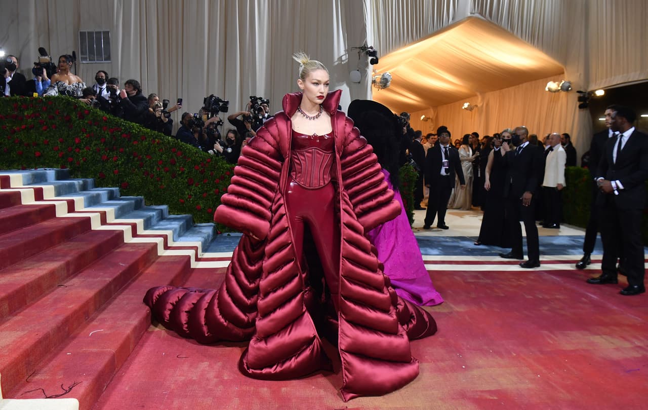 <b>Gigi Hadid</b> lució un estilo completamente opuesto: de gran volumen, aunque también firmado por Versace. Se trató de un traje rojo pegado, con un corset y un abrigo tipo ‘puffer’.
