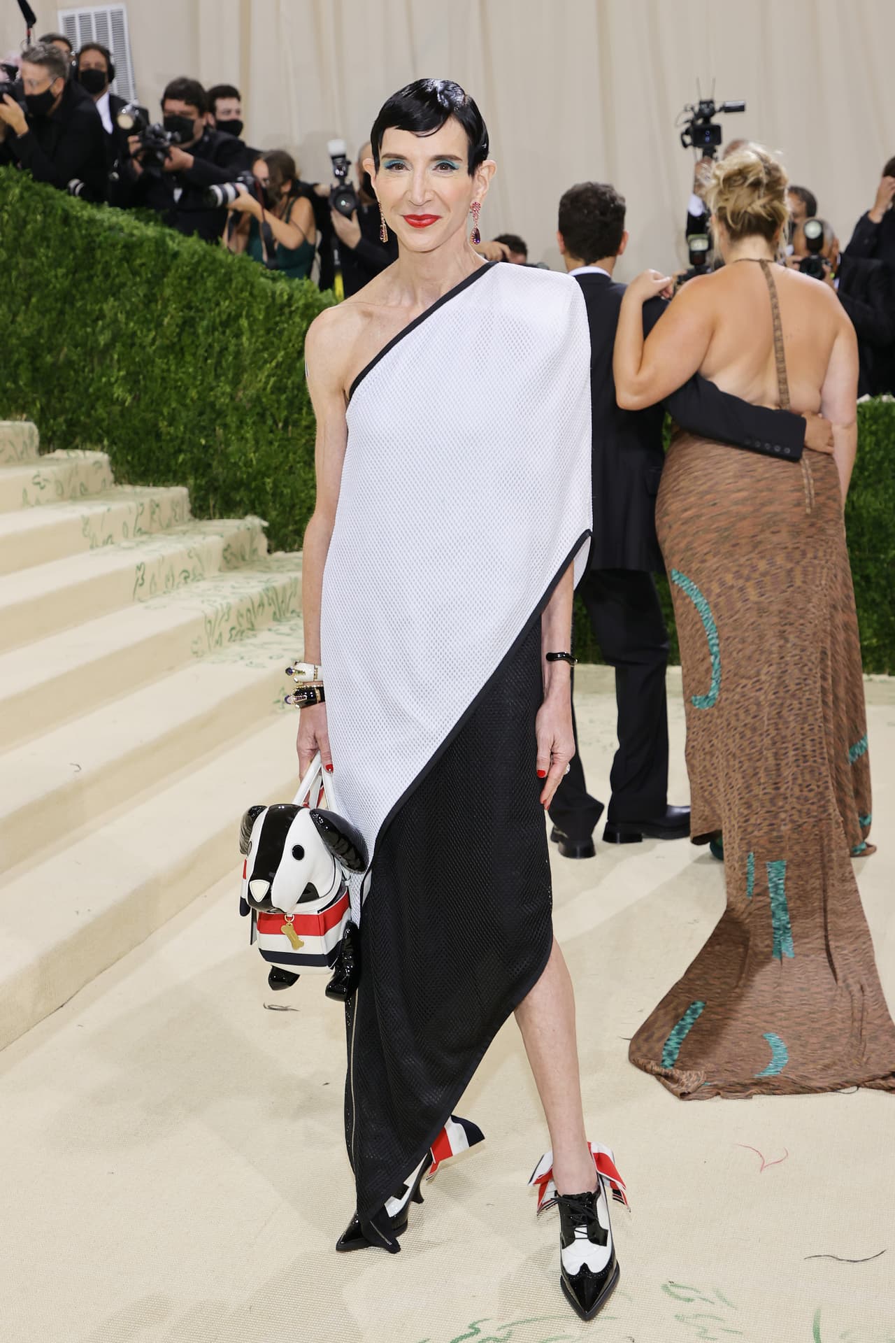 La experta en moda 
<b>Amy Fine Collins </b>también llevó en su look un animal en su atuendo, se trató de un perro como bolso que combinó con el vestido blanco y negro creado por el diseñador Thom Browne.