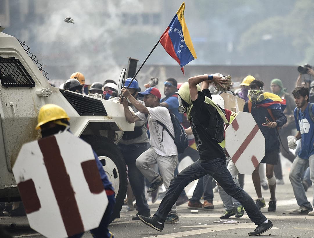 Protesters in Caracas attack a National Guard armored vehicle.