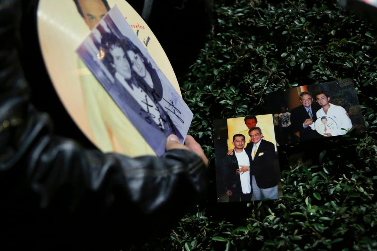 Christian Pacheco, un fan del cantante, muestra fotos personales de sus encuentros con José José mientras los fanáticos lloran su muerte frente a la estatua en Ciudad de México. Este sábado 28 de septiembre, tras el anuncio de la muerte, los fans se movieron hasta la estatua a llevar recuerdos.
<br>