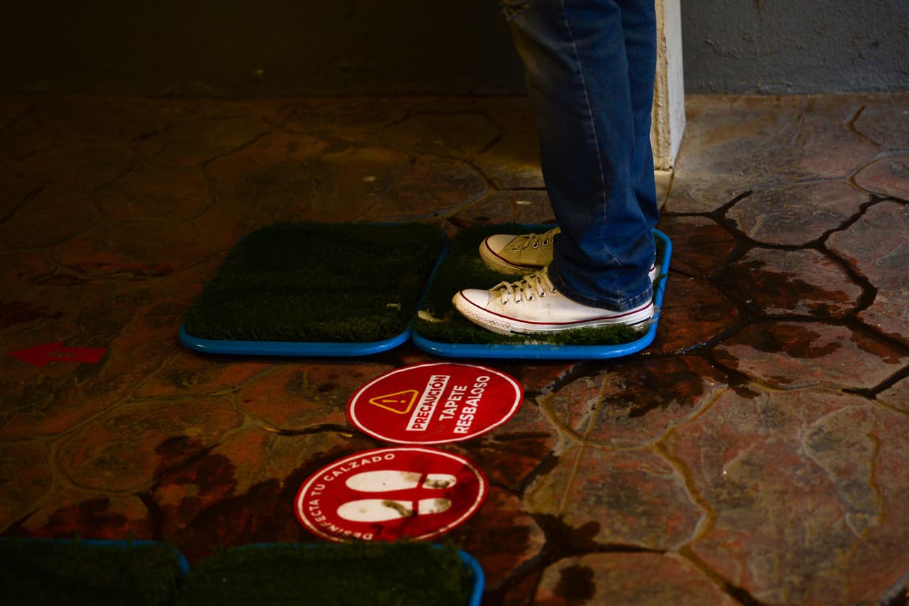 Además, deben pasar por tapetes desinfectantes antes de ingresar al inmueble.